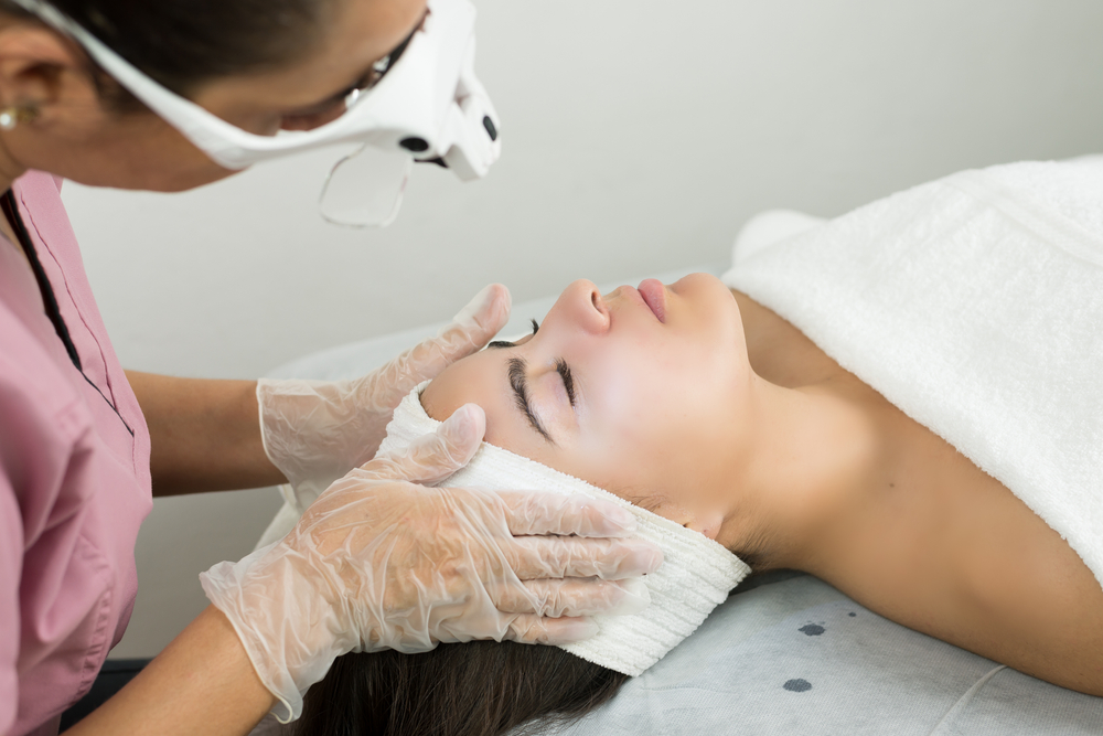 Aesthetician prepares a client’s face for a rejuvenating Diamond Glow Facial procedure.